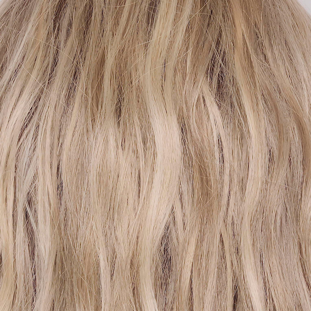 Buttercream Blond-R | The rooted sister of Buttercream Blond is a stunning baby blond shade with a warm chocolate root that exudes elegance and sophistication. This exquisite hair color is meticulously crafted with an array of tonal blond tones, seamlessly woven to perfection. The harmonious blend of light ash, medium honey, and pale gold hues creates a luxurious and radiant finish, giving this shade a touch of class and the perfect balance of blond tones.
